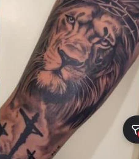 Tatuagem realista de leão no antebraço